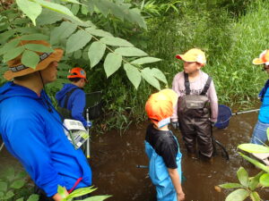 川で調査する子ども