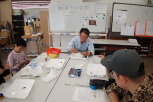 団員に標本作りを指導するトンボの先生
