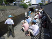 創成川環境整備活動で中学生と一緒に活動の説明を聞くお助け隊