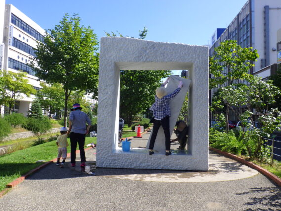 「暑い中で彫刻清掃ボランティアの活動」の画像