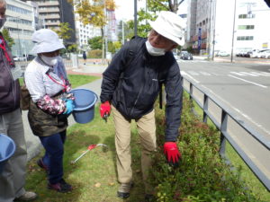 10月6日の得物ボランティアでシモツケの剪定の指導をする笠先生