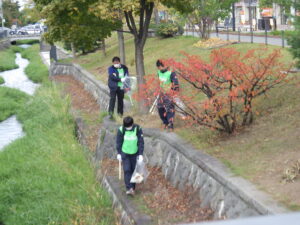 10月19日に北1条の川付近で公園の清掃をする企業ボランティア