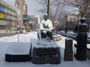 12月13日の雪の降り積もった大友亀太郎像の様子