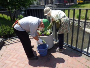 5月26日に狸二条広場のコンテナに花苗を植えこむ花クラブのメンバー7