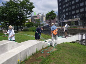 7月27日の活動でスノーリングの清掃をするお助け隊と高校生