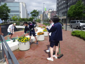 7月27日の活動でスノーリングの清掃をするお助け隊と高校生