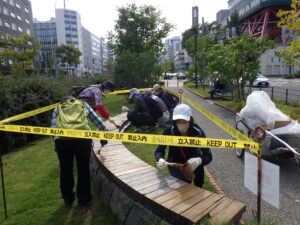 9月28日に北1条北2条の木製円形ベンチの塗装をするお助け隊