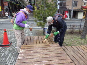 4月19日に狸二条広場の縁台の塗装をするお助け隊のメンバー