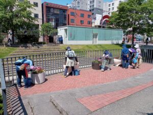 6月8日にコンテナ花壇の手入れをする花くらぶ