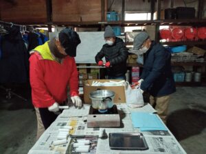 12月6日にロウソク作りをするお助け隊のメンバー