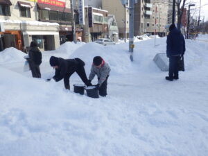 1月20日の創成川公園まちの灯りで、スノーキャンドルづく入りをする親子
