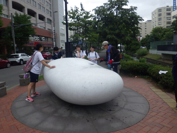 安田侃彫刻「天秘」の清掃をする高校生ボランティアとお助け隊