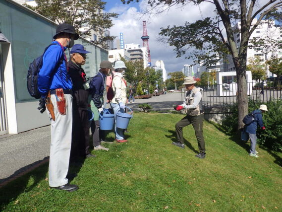 笠先生のハギの説明を聞く植物ボランティア