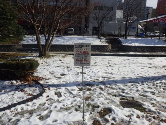 芝生斜面と階段の冬期積雪時立入禁止の看板を設置した様子