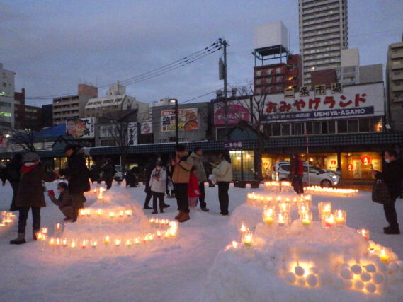 点灯されたスノーキャンドルと見に来た人たちの様子
