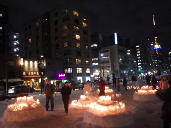 点灯されたスノーキャンドルと見に来た人たちの様子