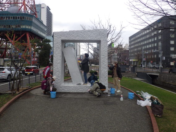 生棒の清掃をする彫刻清掃ボランティア