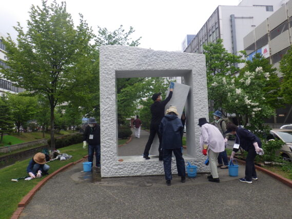 生棒の清掃をする彫刻清掃ボランティア