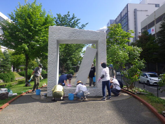 安田侃の彫刻生棒の清掃をする彫刻清掃ボランティア