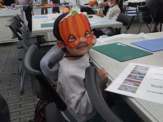 ハロウィンで作ったお面をかぶる子供