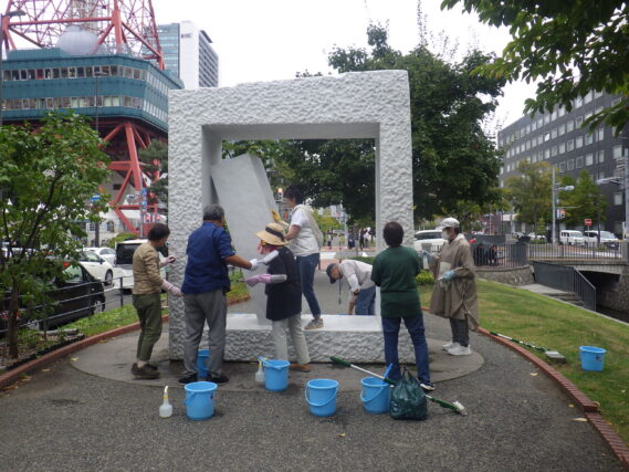 生棒の清掃をする彫刻清掃ボランティア