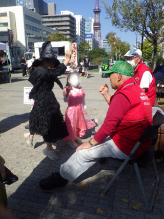 魔女とお菓子じゃんけんをする子供たち