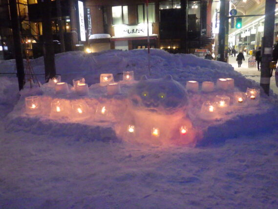 キャラクターの雪像とアイスキャンドルとスノーキャンドルが点灯した様子