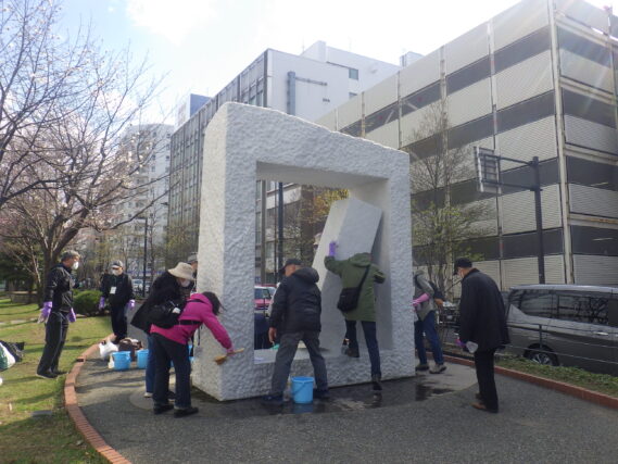 生棒の清掃をする彫刻清掃ボランティア