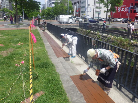 ベンチの塗装をするお助け隊