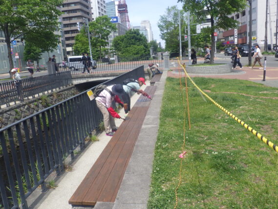 ベンチの塗装をするお助け隊