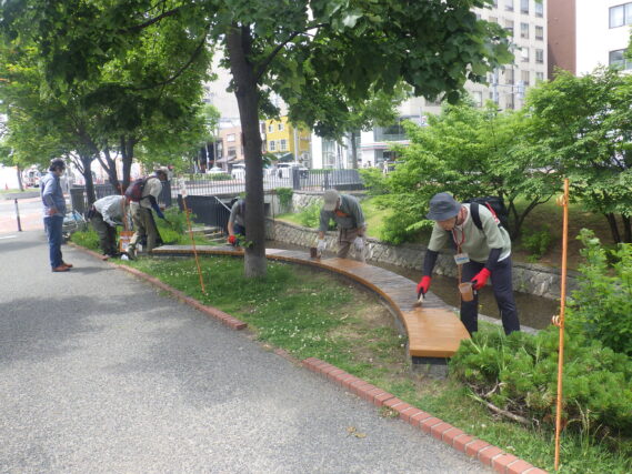 ベンチの塗装をするお助け隊