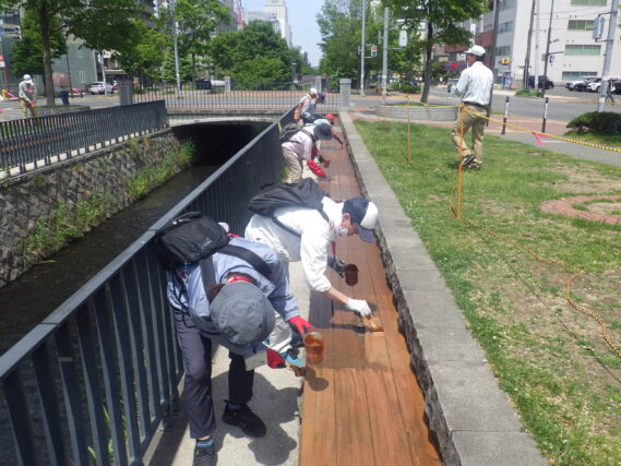 ベンチの塗装をするお助け隊