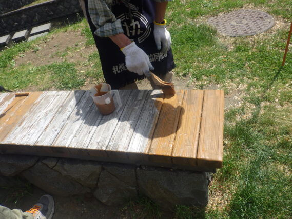 ベンチの塗装をするお助け隊