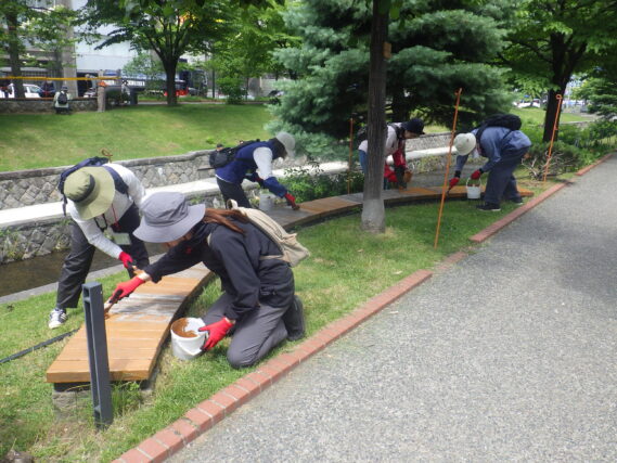 ベンチの塗装をするお助け隊