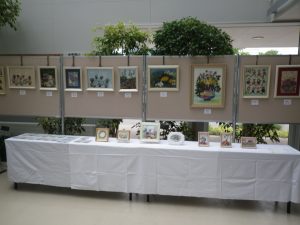 パーテーションには花額机の上にはミニ額やハガキが飾られる