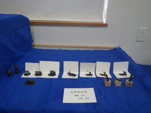 青い毛氈の上に小さい置物が並んでいる