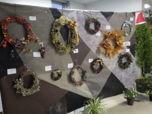 公園の落ち葉や剪定枝、木の実などを使って作ったリースが並ぶ。