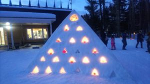 三角すいのオブジェに色とりどりのアイスボードが光るさま