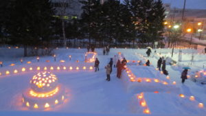 2018年のスノーキャンドル店頭の様子、白い雪の中にオレンジの暖かな光が見える