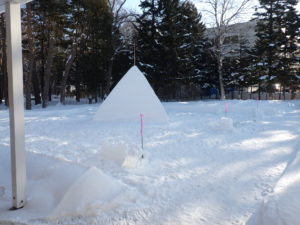 今年のスノーキャンドル会場、雪の広場に三角形の山が見える