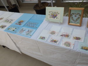 押し花をあしらったファイルやはがきがテーブルに並べられている