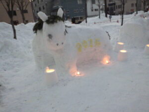 馬の形をした雪像。足元にはスノーキャンドルの灯りがともる。御中には2026の黄色い文字がある。